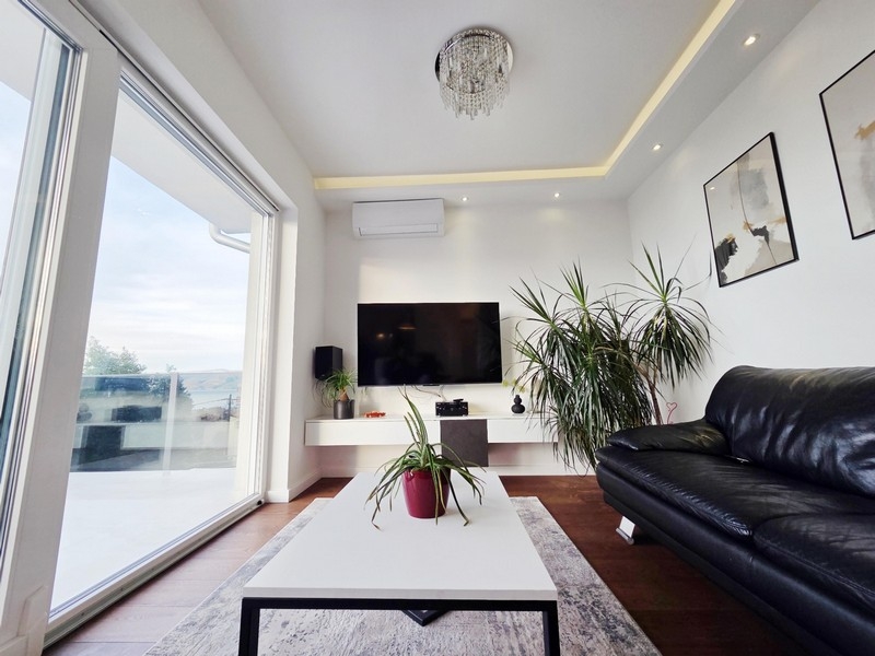 Nappali nagy üveg előlappal és kijárattal a tengerre néző teraszra