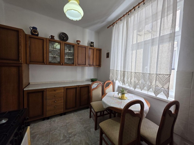 Konyha fa szekrényekkel és kis ülősarokkal