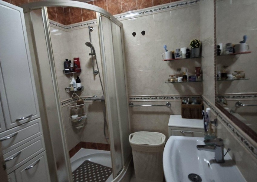 Fürdőszoba zuhanyzóval, mosdóval és tükörrel