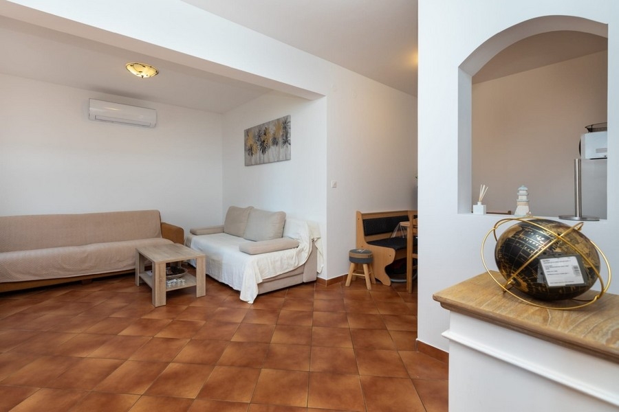 A lakás nappalija ülőgarnitúrával és átjáróval a konyhába