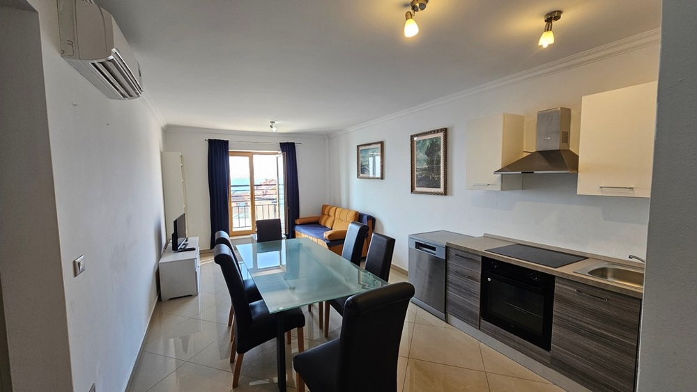 Világos nappali nyitott konyhával, étkezővel és tengerre néző kilátással