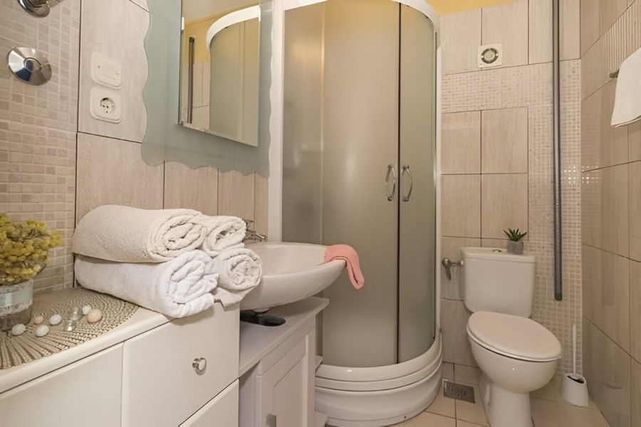 Fürdőszoba zuhanyzóval és mosdóval