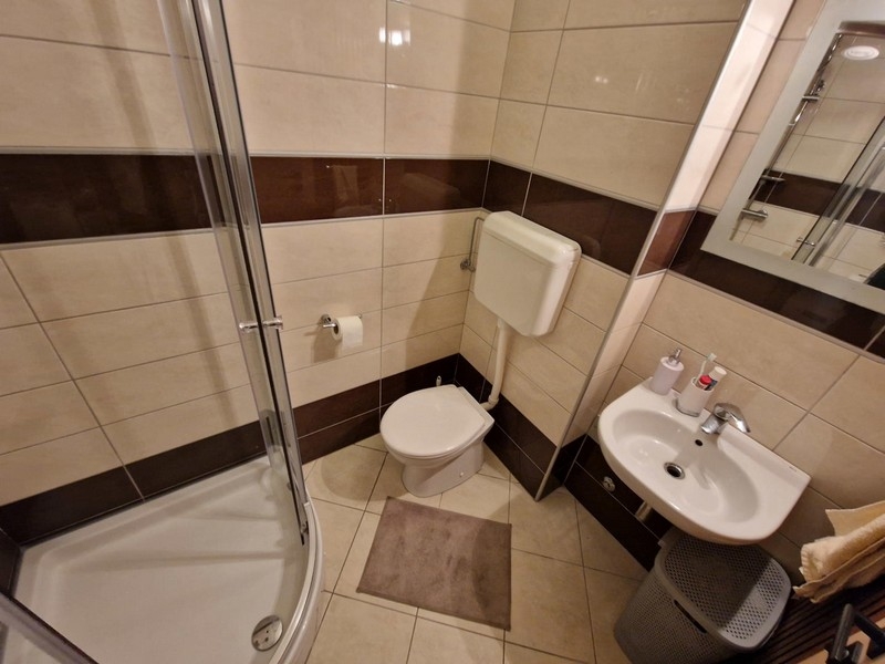 Fürdőszoba zuhanyzóval és mosdóval