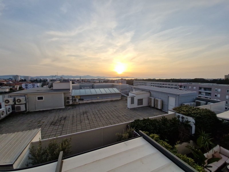 Tengerre néző kilátás a városra naplementekor