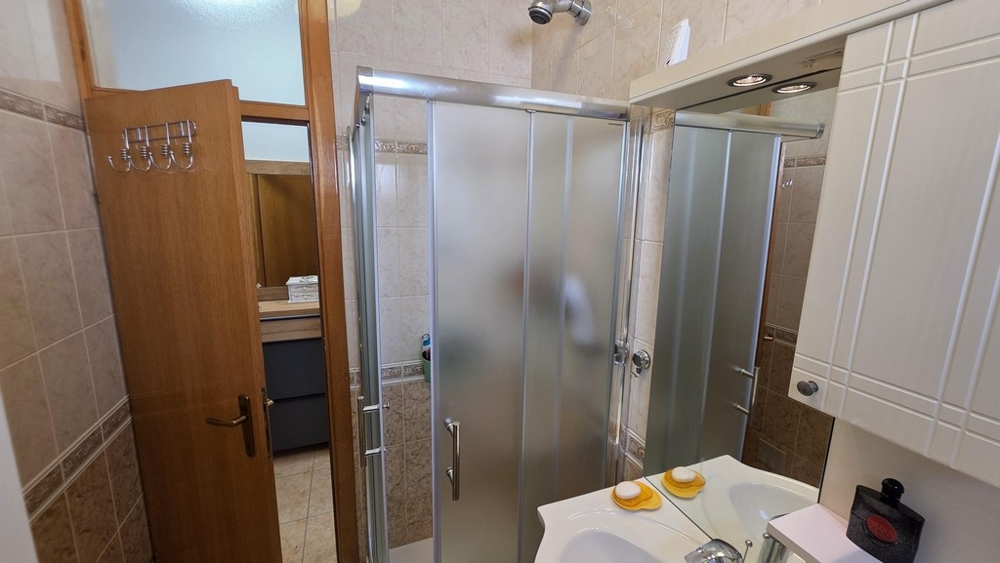 Fürdőszoba zuhanykabinnal és mosdóval