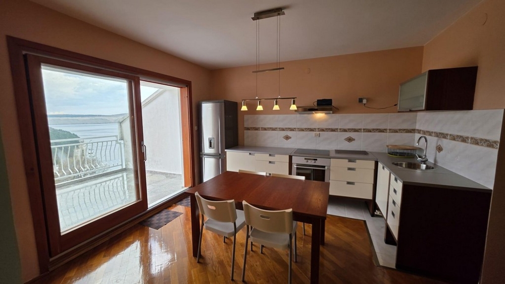 Nyitott konyha beépített gépekkel és étkezővel