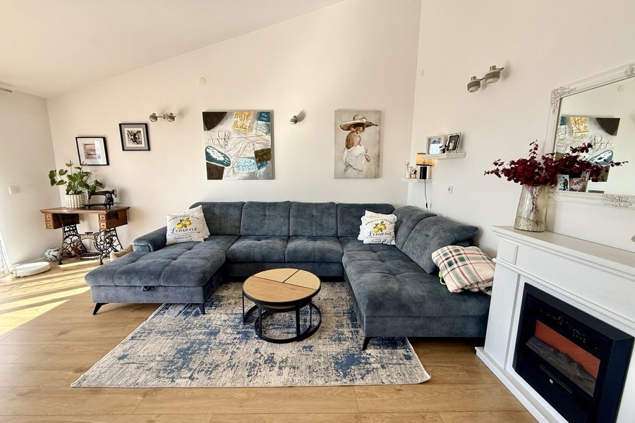 Világos nappali nagy kanapéval és modern hangulattal