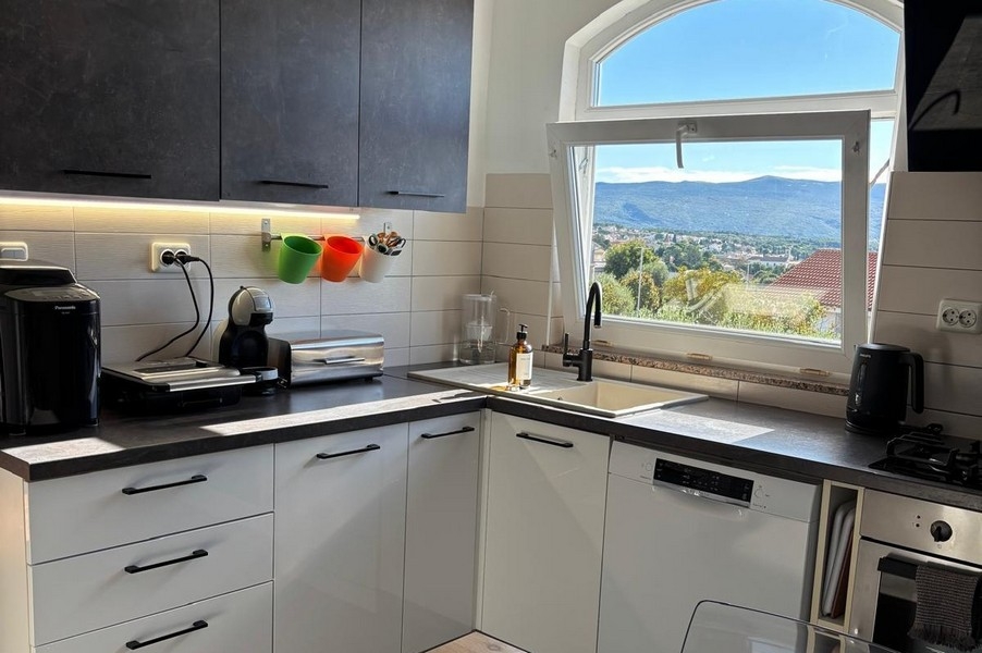 Tengerre néző kilátás a konyhából a háztetőkre és a tengerparti tájra