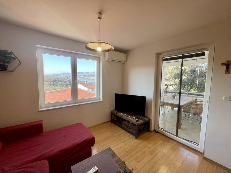 Nappali kanapéval, TV-vel és tengerre néző erkéllyel