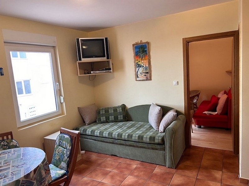 Kompakt nappali kanapéval, televízióval és hozzáféréssel a hálószobához