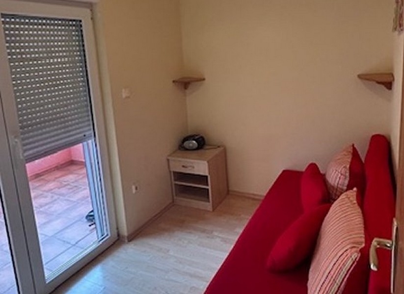 Hálószoba piros kanapéval és kijárattal az erkélyre