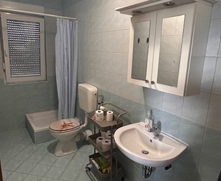 Fürdőszoba zuhanyzóval, mosdóval és ablakkal