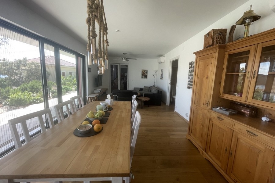 Nyitott nappali és étkező nagy ablakokkal és kilátással a vidékre