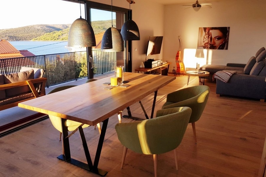 Nyitott nappali kanapéval, étkezőasztallal és kijárattal az erkélyre