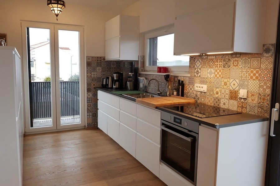 Modern konyha beépített gépekkel és dekoratív csempézett splashback