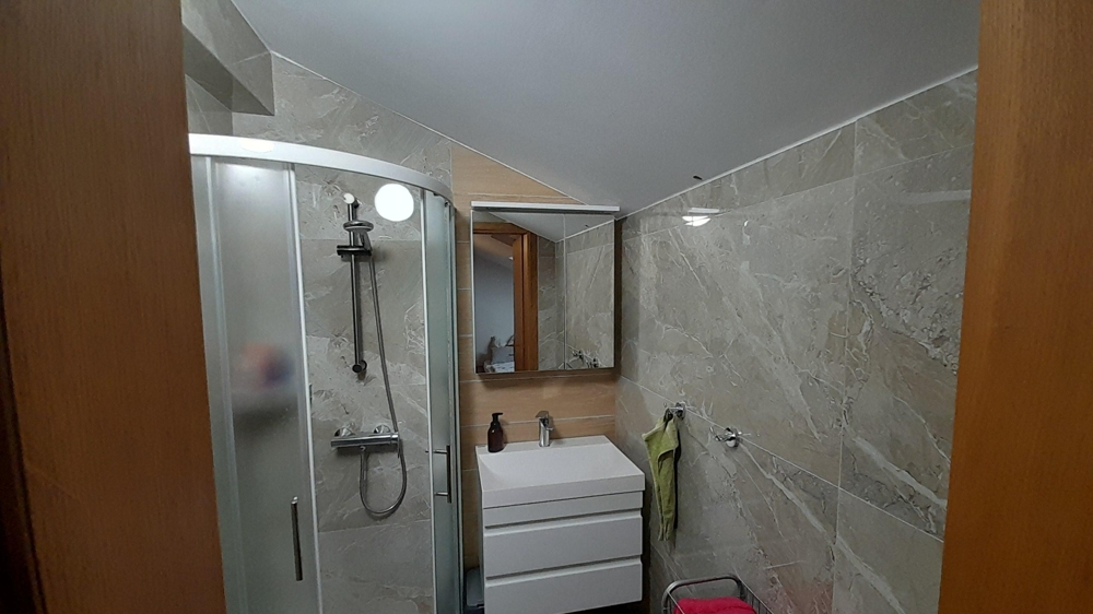 Modern fürdőszoba zuhanyzóval és mosdóval