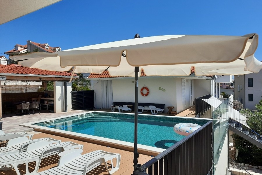 Medencerész napozóterasszal és nyugágyakkal