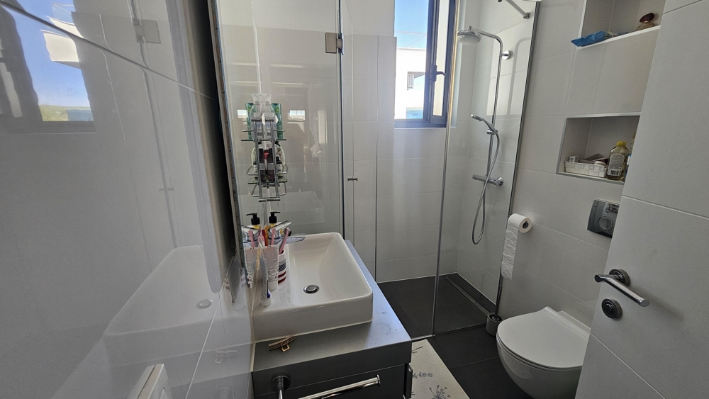 Modern fürdőszoba zuhanyzóval és ablakkal