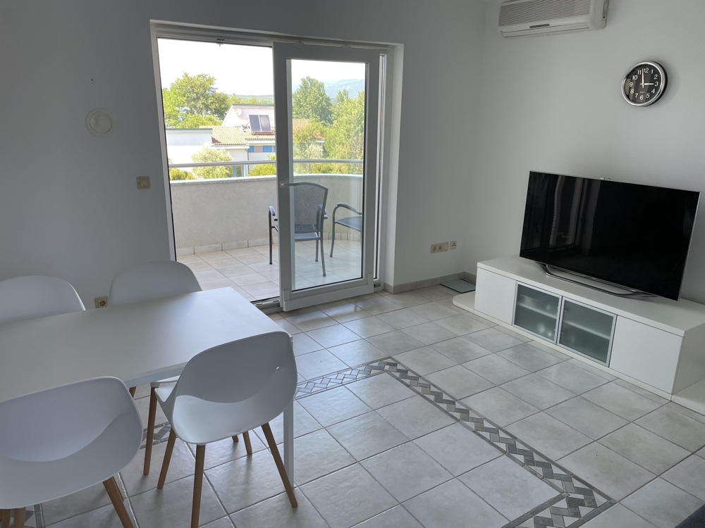 A nagy ablakon keresztül tengerre néző erkély