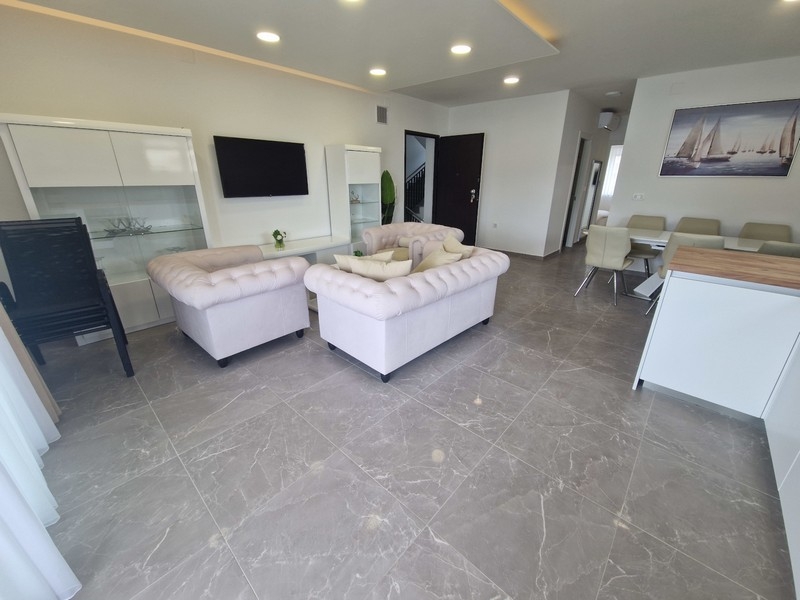 Nyitott nappali konyhával és tengerre néző kilátással a modern apartmanban