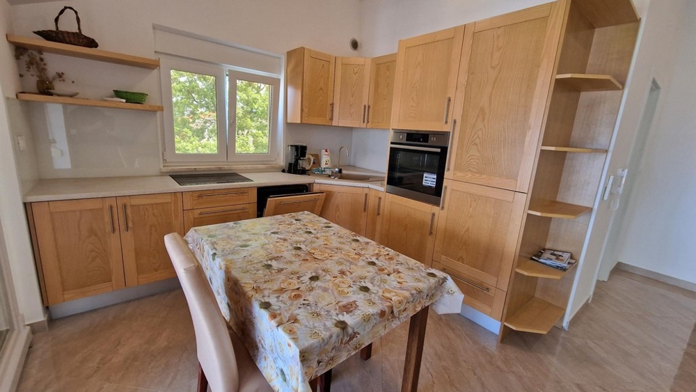 Fából készült konyhasarok étkezővel az apartmanban Njivice városában