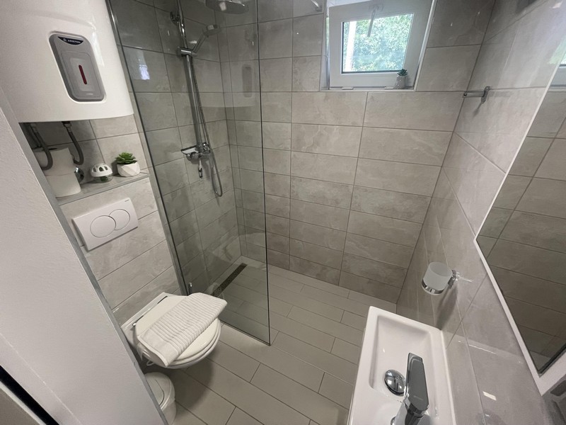 Fürdőszoba zuhanykabinnal a Njivice-i apartmanban