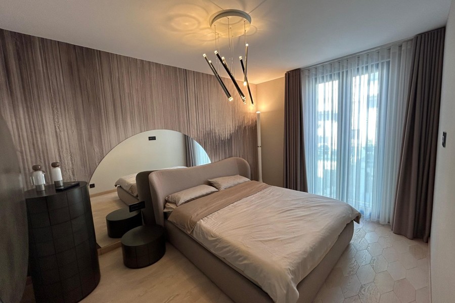 Hálószoba kárpitozott ággyal és designlámpával