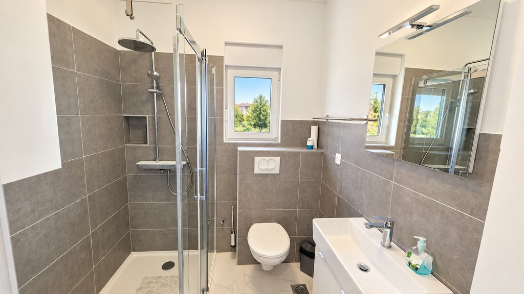 Fürdőszoba zuhanyzóval és WC-vel