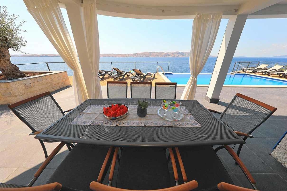 Kilátás a terasz fedett részére, kilátással a medencés társalgóra.