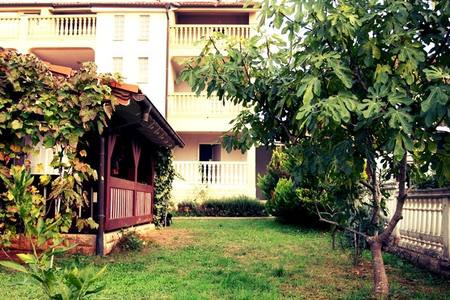 A ház kertje, kilátással a ház hátsó részére, az erkélyekkel.