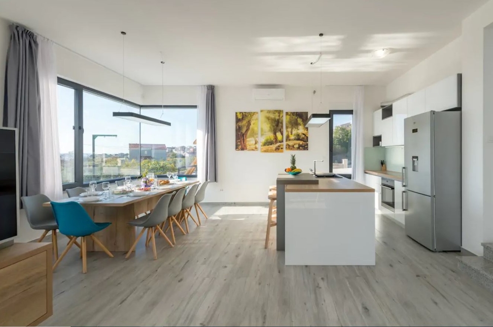 Modern nappali nyitott konyhával és étkezővel.