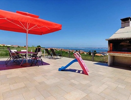 Terasz grillsütővel és panorámás kilátással a tengerre.