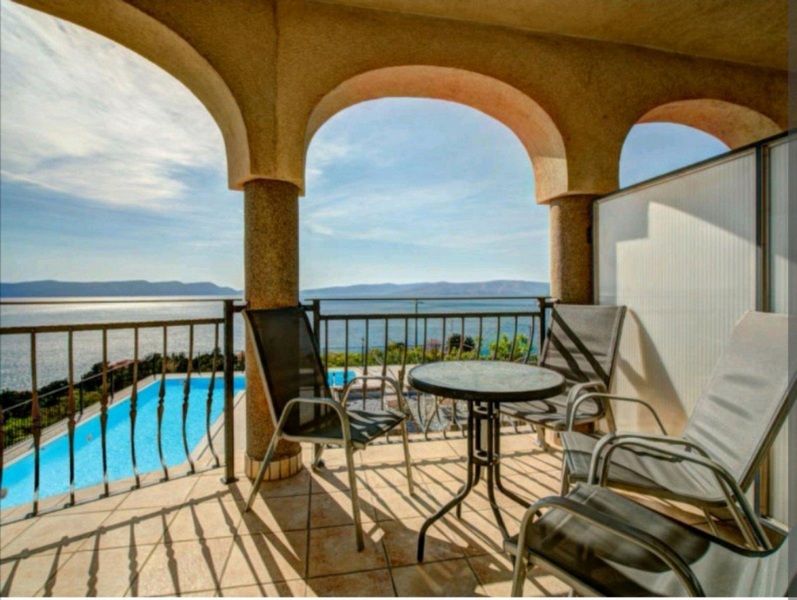 Az emeleti fedett teraszról kilátás nyílik a medencére és a tengerre.