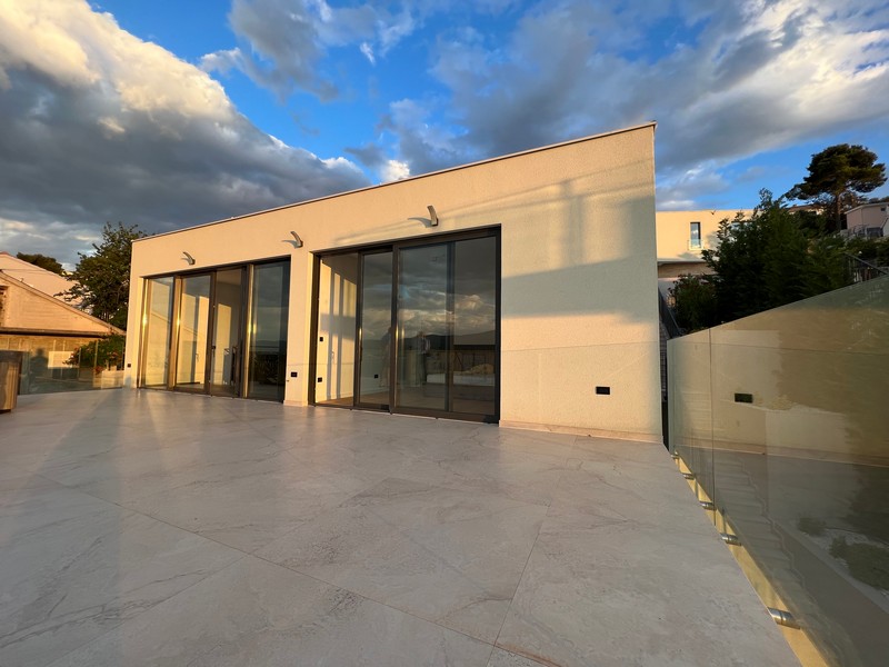 Nappali kilátással a medencére és a tengerre a H1921 ingatlanon, Ciovo Island, Horvátország.