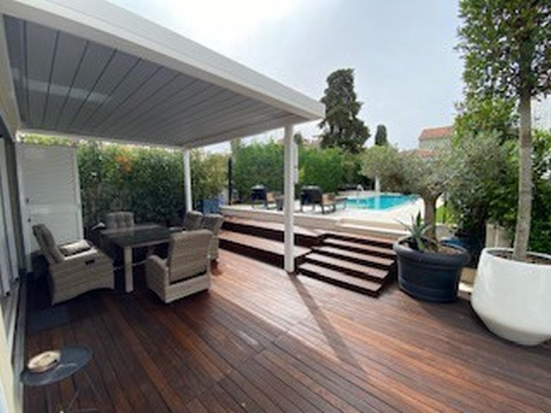 Az isztriai luxusvilla medencéjére néző félig fedett fa terasz eladó.