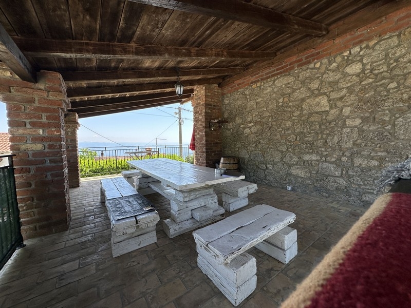 Terasz étkezővel és kilátással a tengerre.