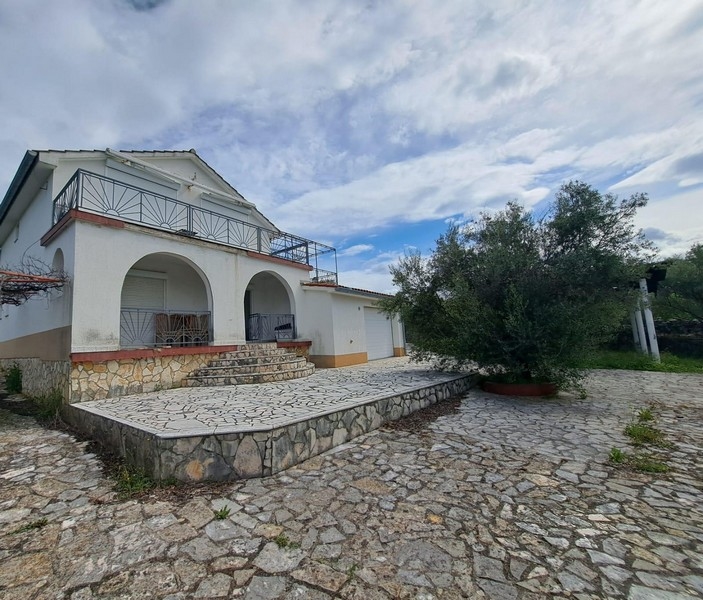 Ház és kilátás a kövezett udvarra az épület előtt.