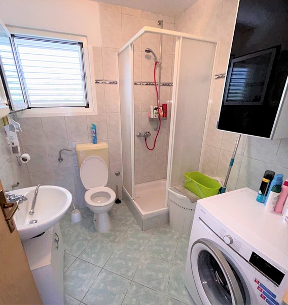 Egyszerű fürdőszoba zuhanyzóval.