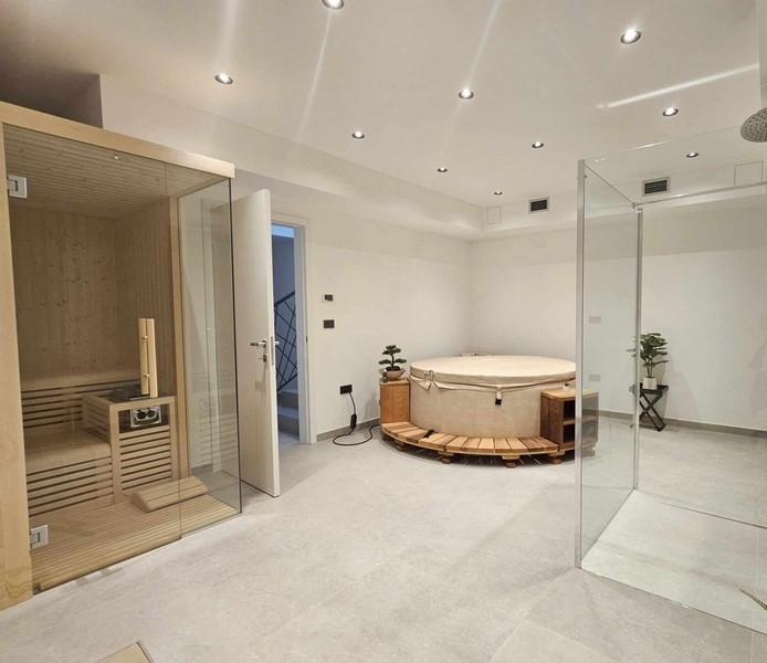 Nagy wellness részleg jakuzzival, szaunával és zuhanyzóval.