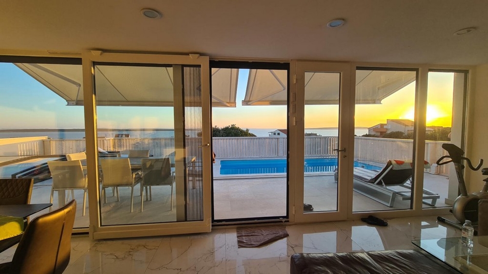 A horvátországi H2724 ingatlan vonzó nappalijából kilátás nyílik a tengerre és a medencére.