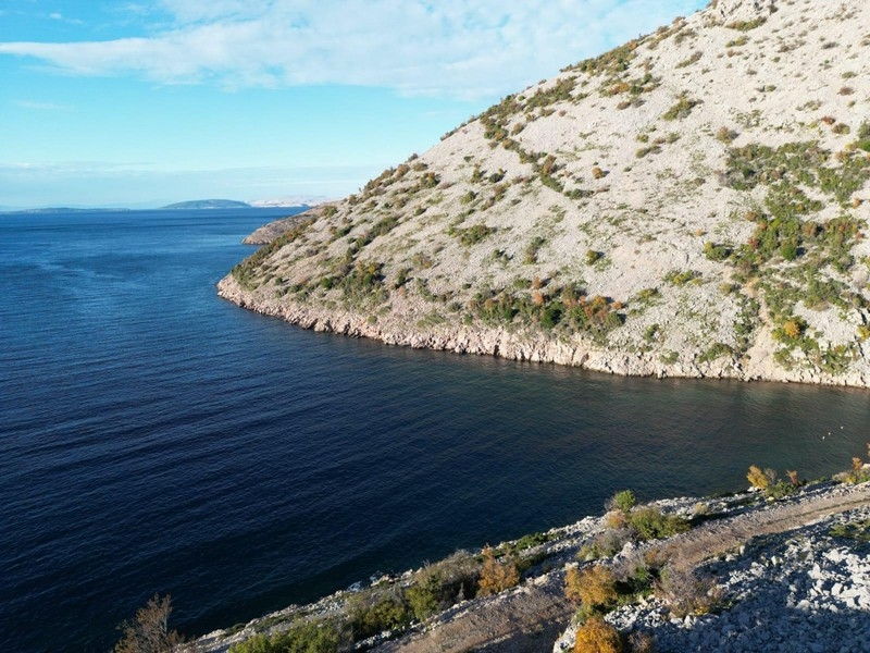 Csendes tengerpart egy horvát ingatlan közelében a piacon, kiemelve a panorámát.