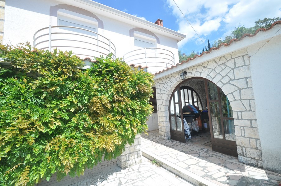 Mediterrán ház bejárata a tenger mellett Horvátországban, kő építészettel.