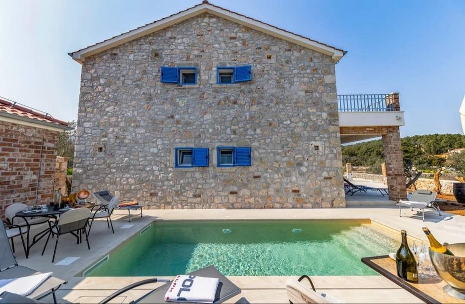 Eladó egy horvát kővilla hátulnézete saját medencével és grillezővel.