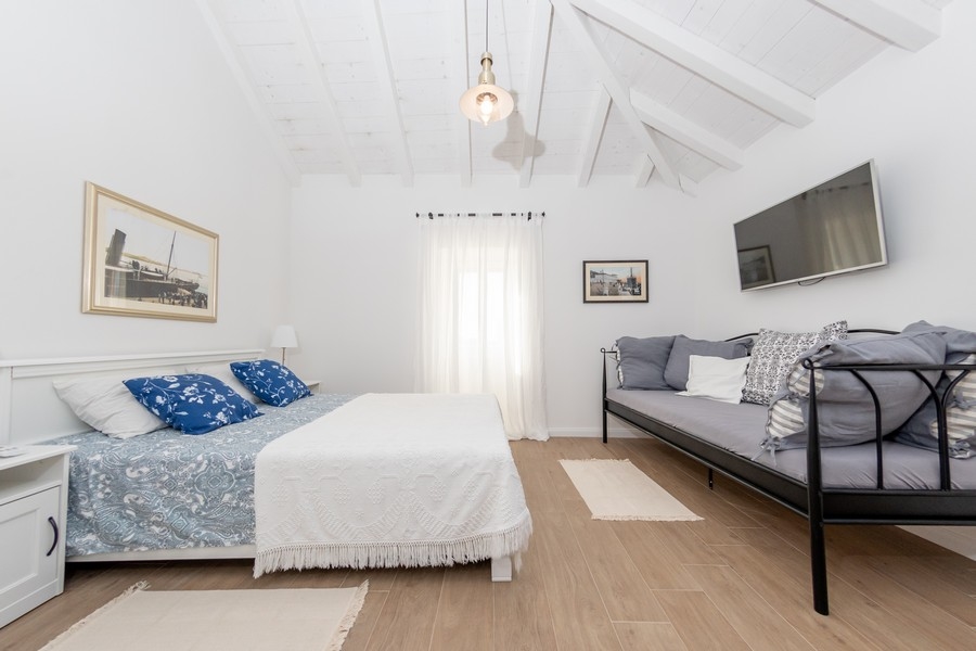 Hangulatos hálószoba ferde mennyezettel és természetes fénnyel egy horvát ingatlanban