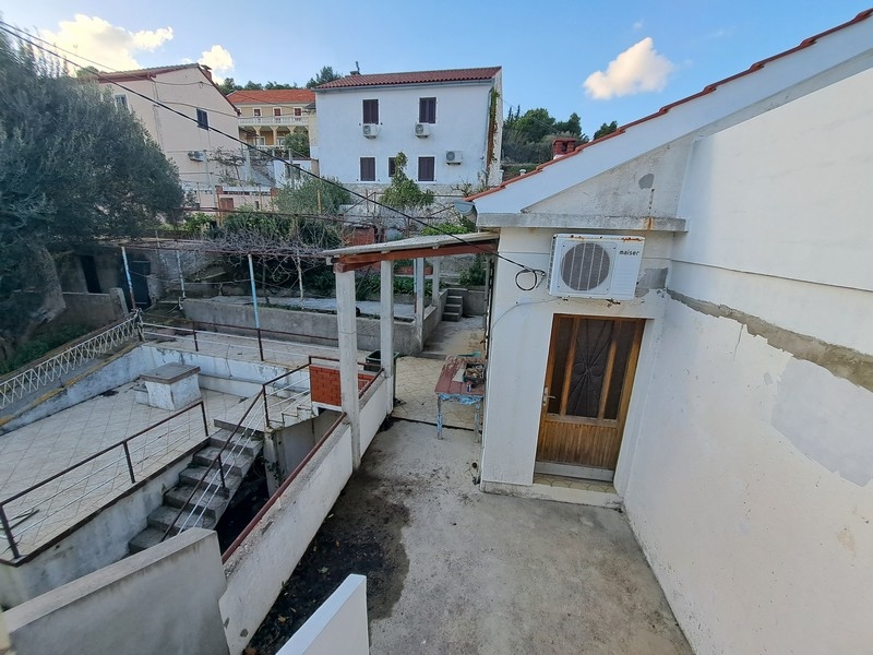 A Panorama Scouting által eladásra kínált horvát ingatlan hátsó udvara fedett terasszal, lépcsőkkel.