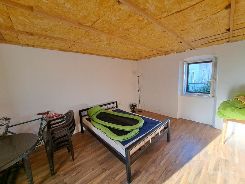 Világos hálószoba fa mennyezettel és minimalista dekorációval egy horvátországi ingatlanban, elérhető a Panorama Scouting szolgáltatáson keresztül.