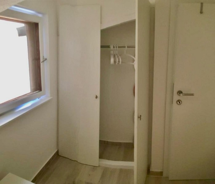 Kis gardrób a kőházban polcokkal és ruhaakasztóval, egyszerű berendezéssel