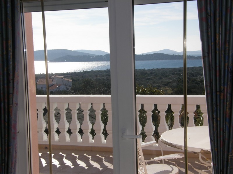 Tengerre néző kilátás a horvát villa teraszáról fehér korlátokon keresztül