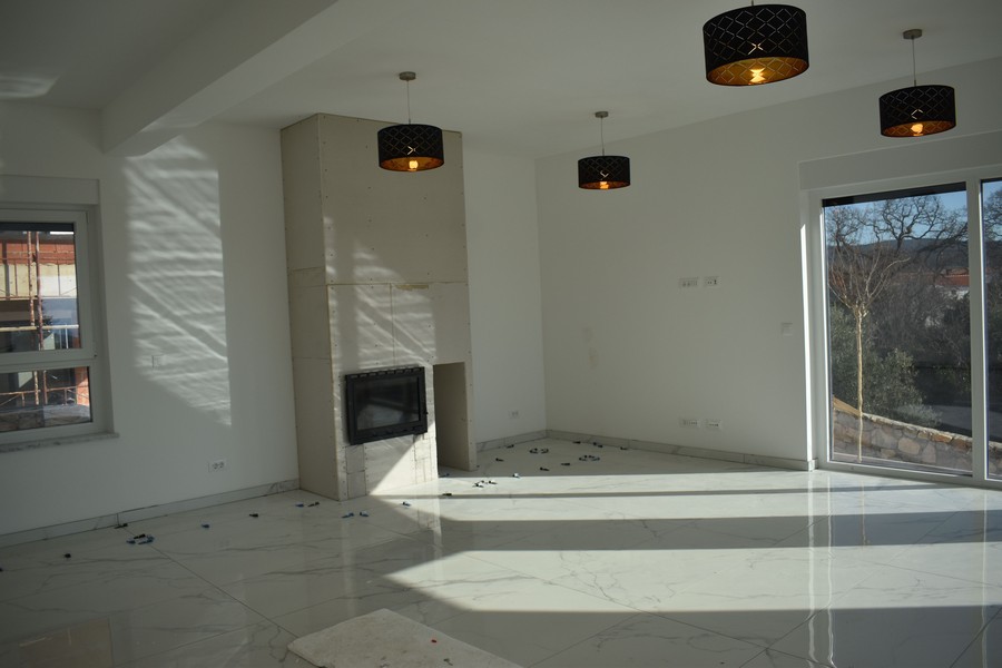 Belső nézet egy kandallóval ellátott nappaliról és a természetről egy villában Krk-n.