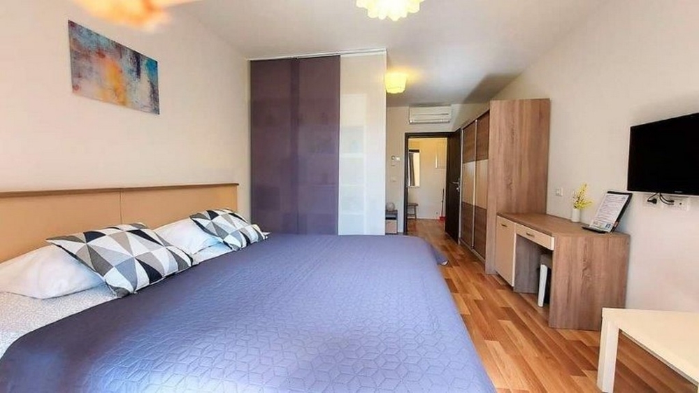 Hálószoba a ház három lakásának egyikében Isztriai eladó, nagy ággyal, szekrénnyel és TV-vel.